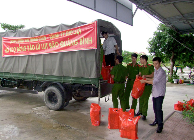 Đoàn công tác xã hội từ thiện của Báo CAND và Công ty Duy Lợi sắp xếp hàng cứu trợ lên xe để đưa về vùng lũ Quảng Bình