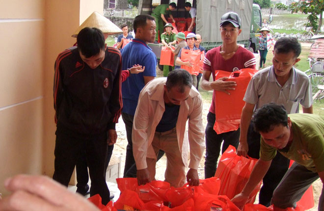 Đoàn công tác của Báo CAND và Công ty Duy lợi cùng Công an thị xã Ba Đồn và người dân vận chuyển hàng cứu trợ để giúp đỡ bà con