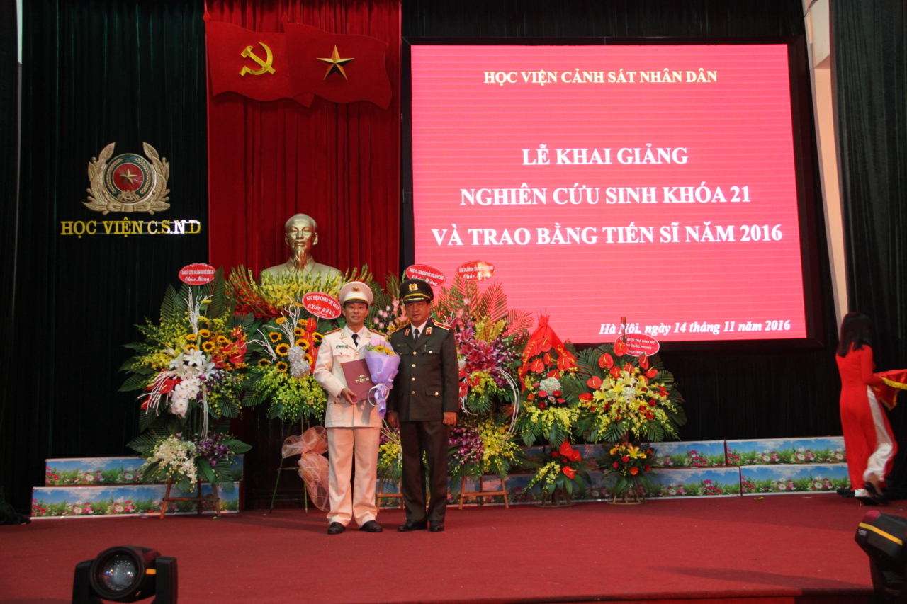 Đồng chí Thiếu tướng, PGS.TS Đỗ Ngọc Cẩn, Phó Tổng cục trưởng Tổng cục Chính trị CAND trao bằng tiến sĩ cho đồng chí Trung tá Hoàng Giang Nam.