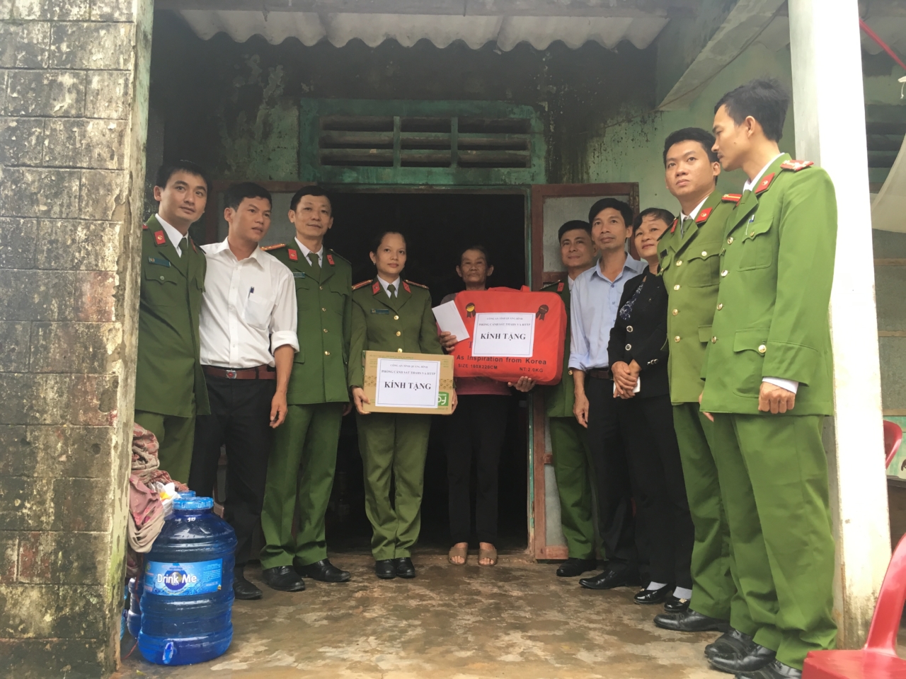 Đại diện chỉ huy đơn vị, đoàn thanh niên, hội phụ nữ phòng PC81 và đại diện chính quyền của xã tặng quà cho hộ gia đình Bà Nguyễn Thị Nghẻn thôn 6 xã Lý Trạch, huyện Bố Trạch.